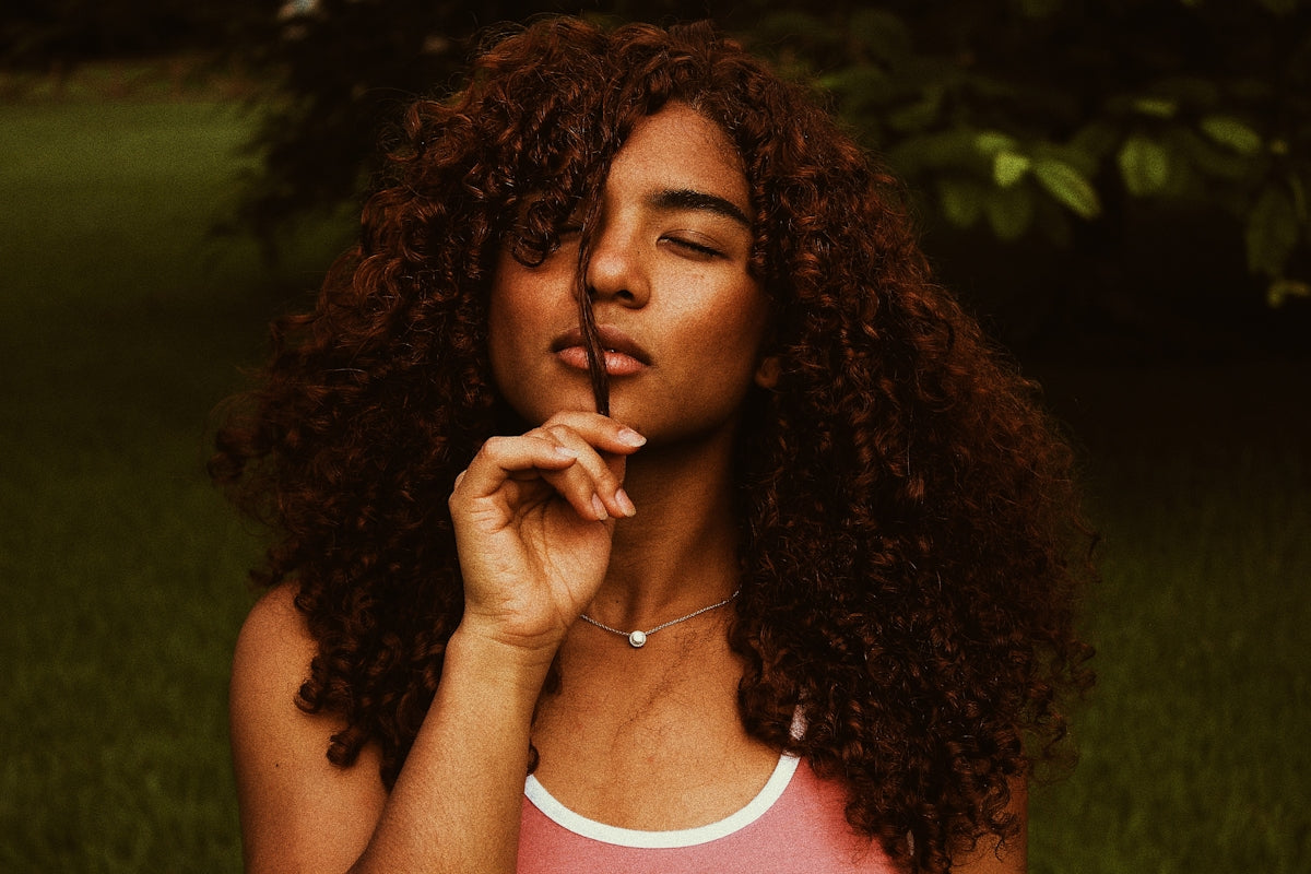 curly haired woman wearing white and red tank top