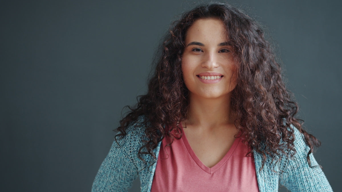 A smiling woman with curly dark hair