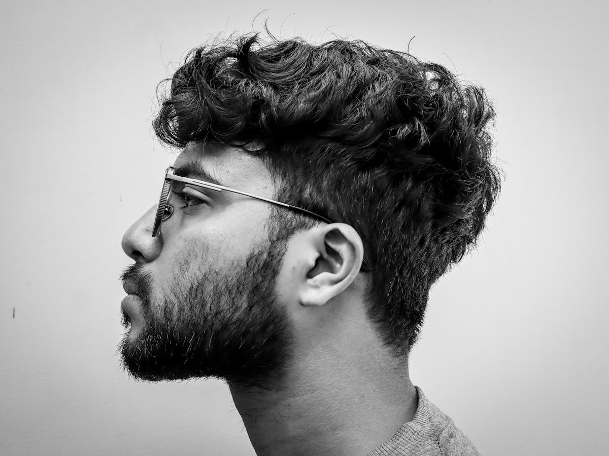 Man with glasses and curly hair in profile.